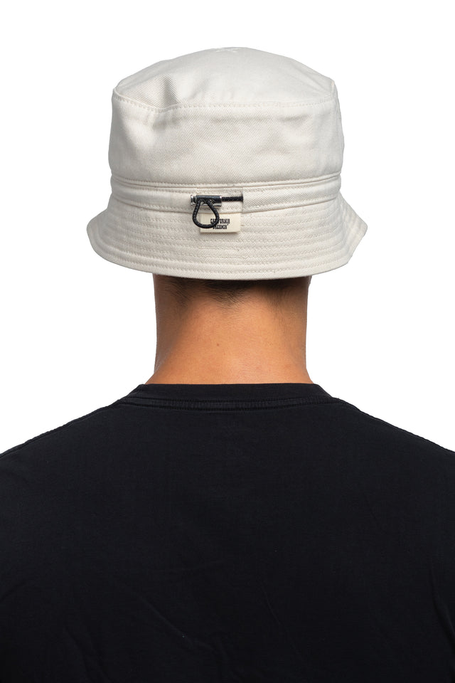 Back view of tapered bucket hat in bone colorway on model.