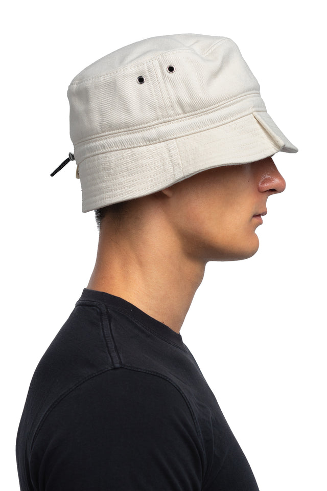 Side view of tapered bucket hat in bone colorway on model.