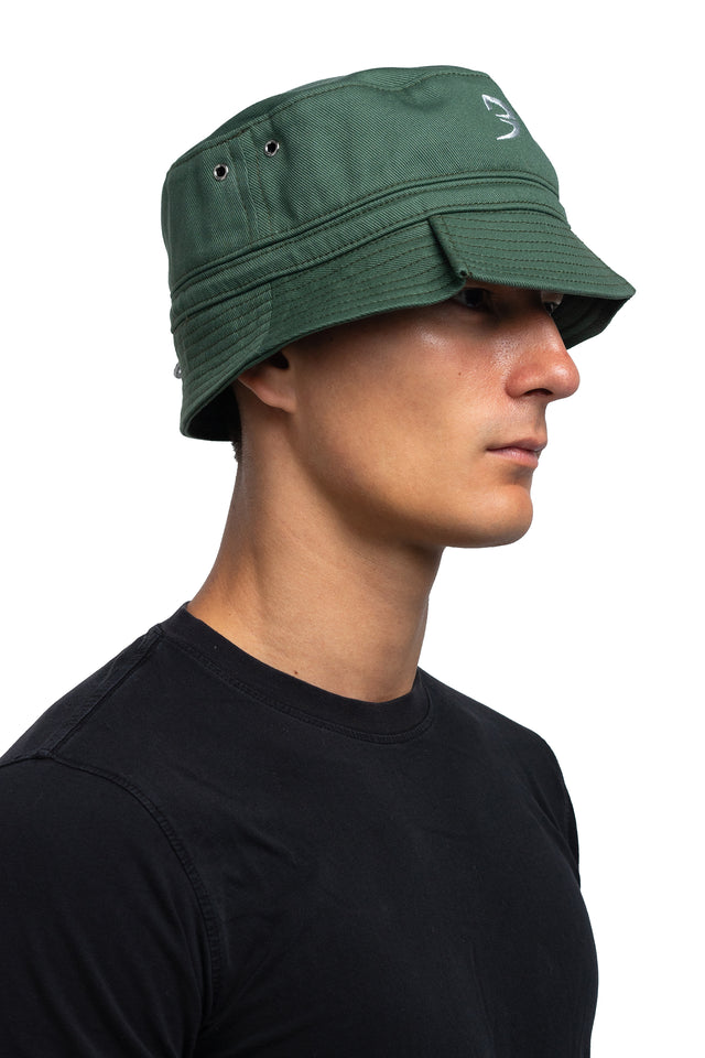 Three quarter front view of tapered bucket hat in evergreen colorway on model.