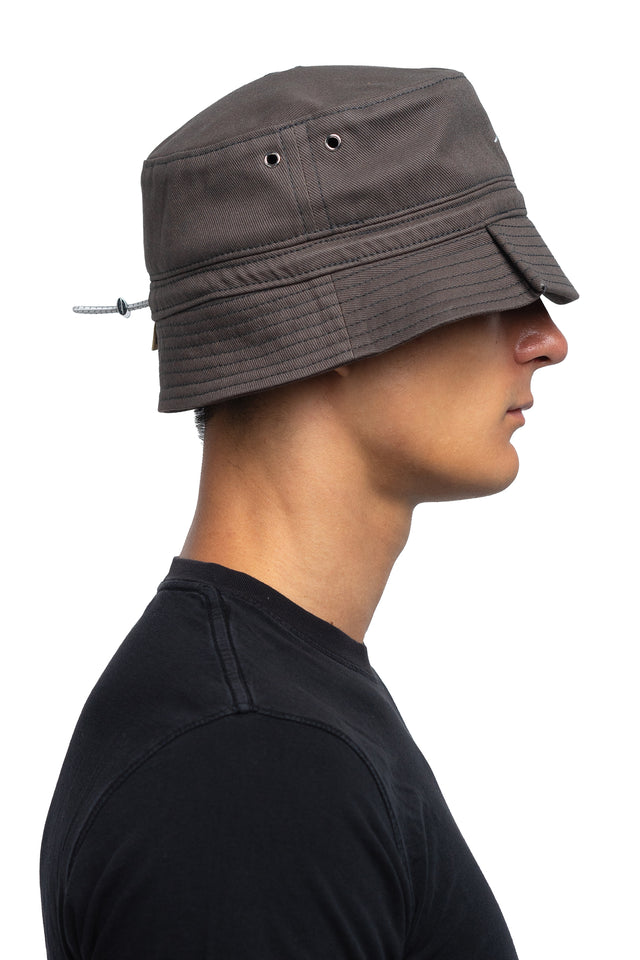 Side view of tapered bucket hat in graphite colorway on model.