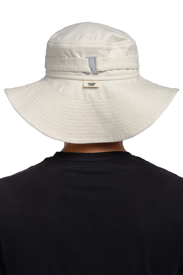 Back view of floppy bucket hat in bone/eggshell colorway worn on model with sides unsnapped in natural state.