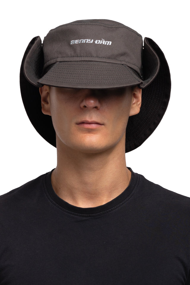 Front view of floppy bucket hat in graphite/espresso colorway worn on model with side of hat snapped up to show convertibility of style.