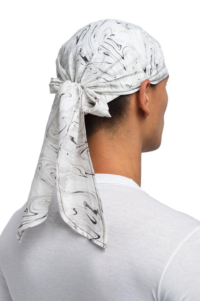 Three quarter back view of black & white colorway bandana hat worn on model.