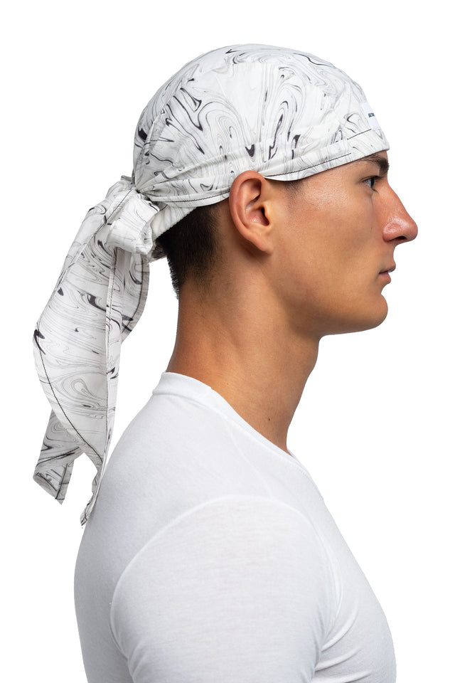 Side view of black & white colorway bandana hat worn on model.