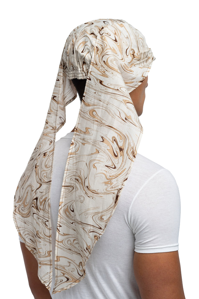Three quarter view of brown & cream colorway bandana hat worn on model with side panels untied.