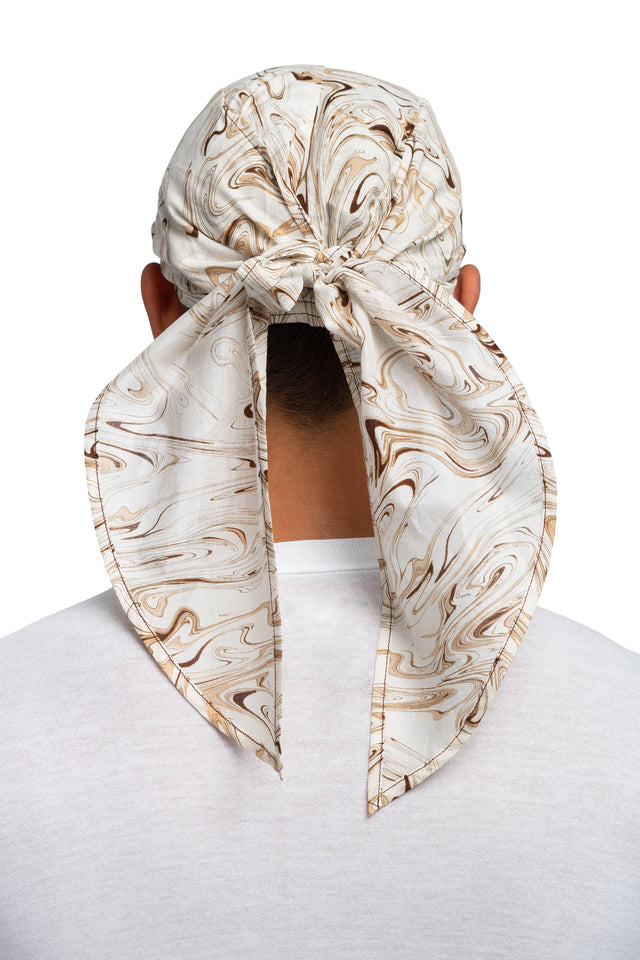 Back view of brown & cream colorway bandana hat worn on model with side panels tied together.