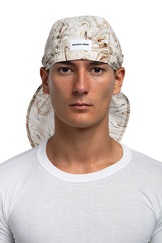 Front view of brown & cream colorway bandana hat worn on model.