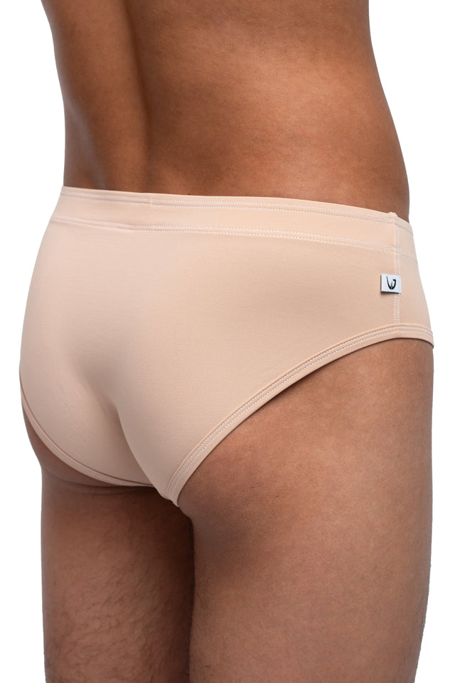 Three quarter back view of classic briefs underwear on model in desert peach colorway. (Close up)