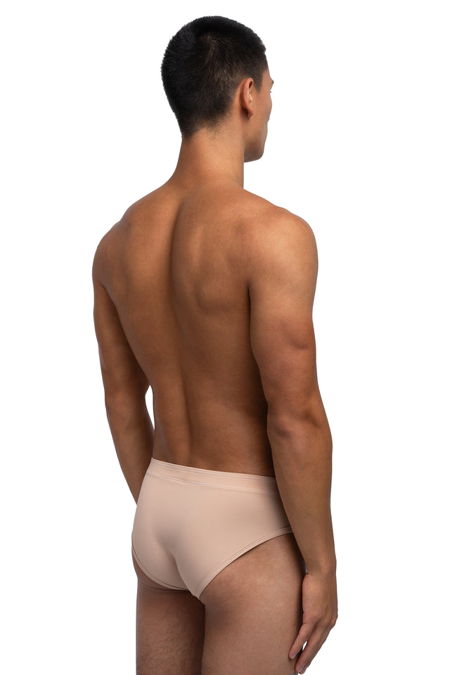 Three quarter back view of classic briefs underwear on model in desert peach colorway.