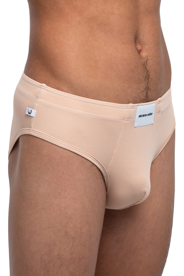 Three quarter front view of classic briefs underwear on model in desert peach colorway. (Close up)