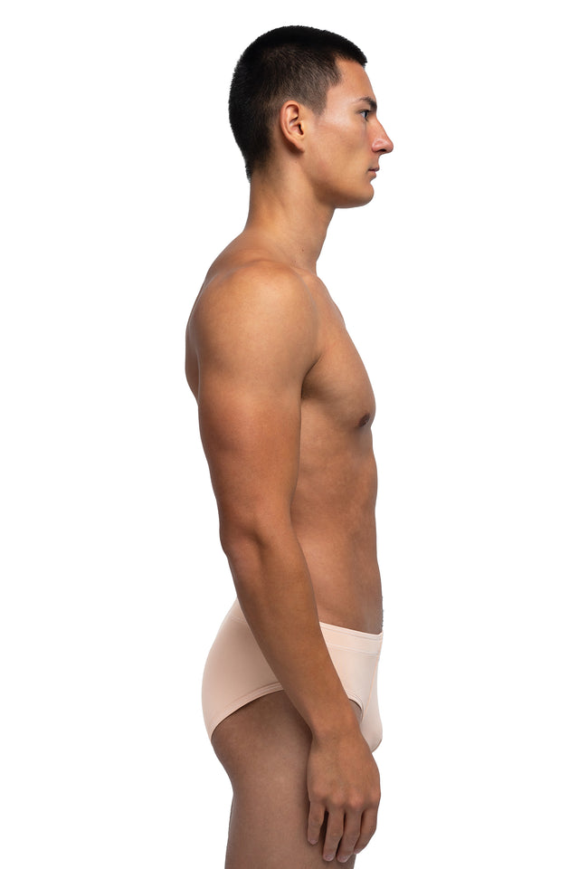 Side view of classic briefs underwear on model in desert peach colorway.