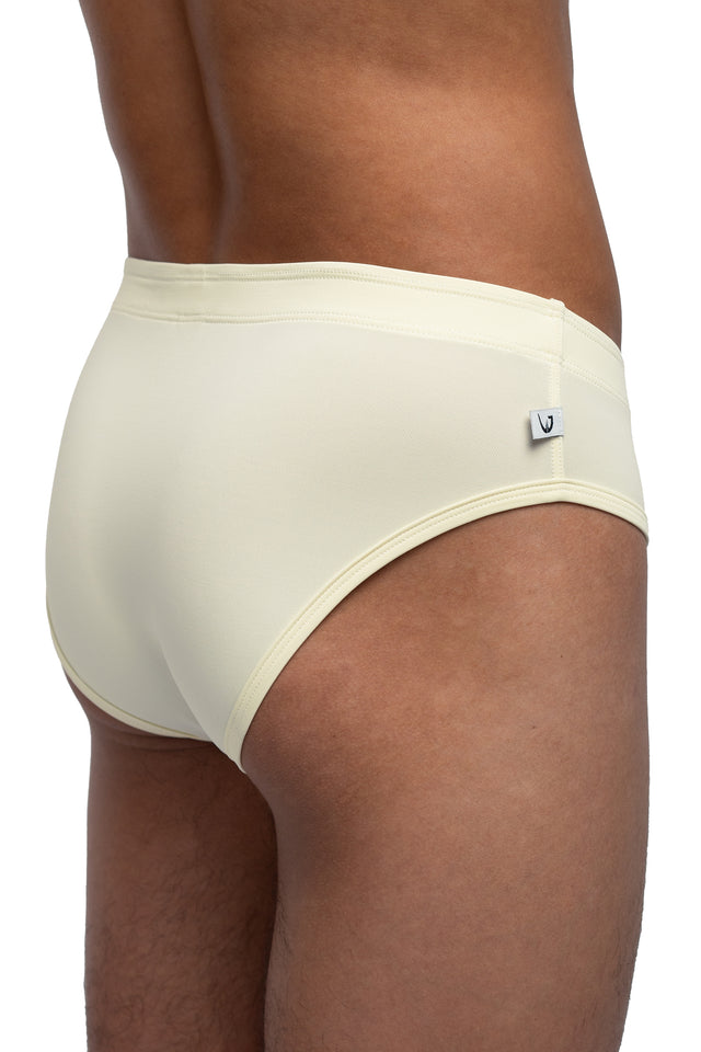 Three quarter back view of classic briefs underwear on model in eggshell colorway. (Close up)