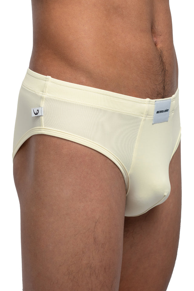 Three quarter front view of classic briefs underwear on model in eggshell colorway. (Close up)