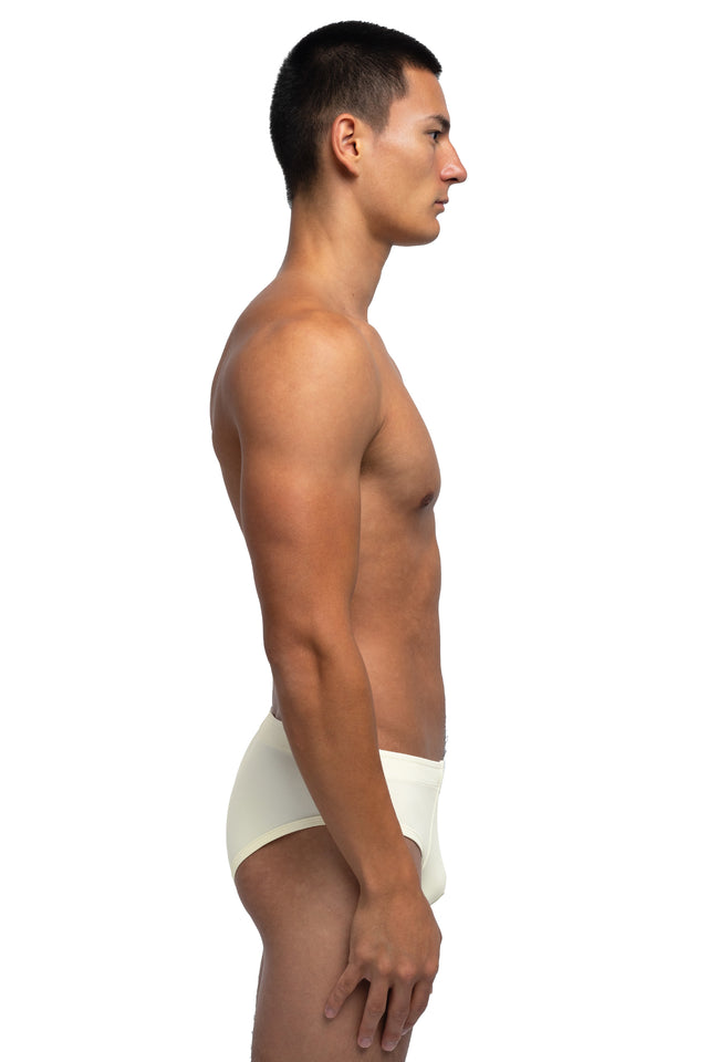 Side view of classic briefs underwear on model in eggshell colorway.