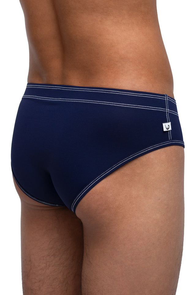 Three quarter back view of classic briefs underwear on model in midnight blue. (Close up)