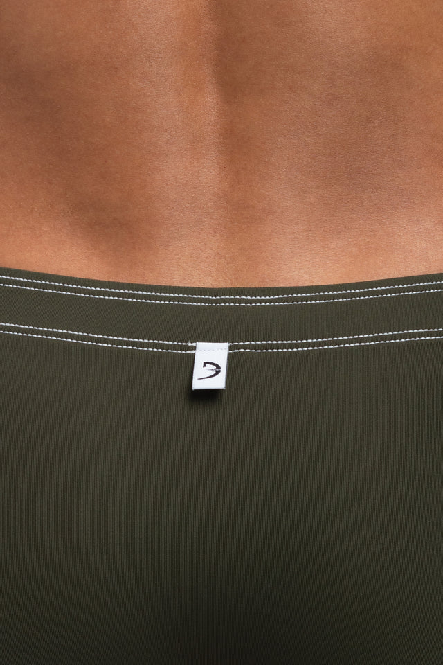 Back view of boxer briefs logo tag on underwear on model in dark olive colorway. (Close up)