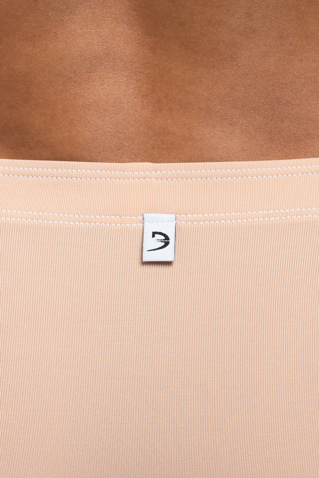 Back view of boxer briefs logo on underwear on model in desert peach colorway. (Close up)