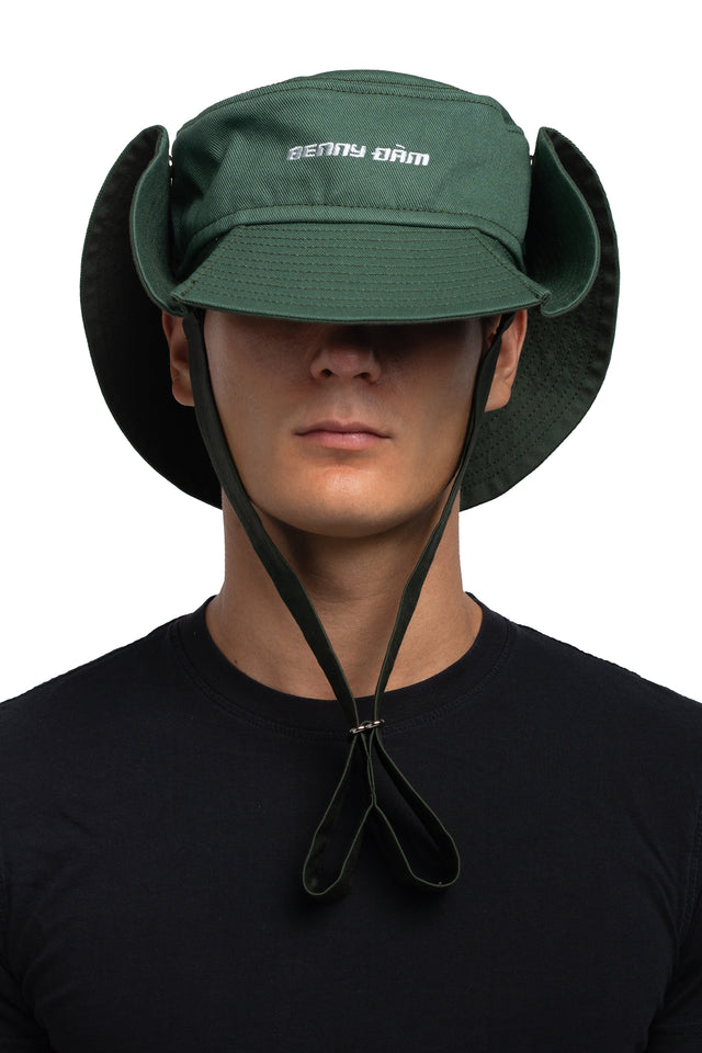 Front view of floppy bucket hat in evergreen/pine colorway worn on model with side of hat snapped up to show convertibility of style.