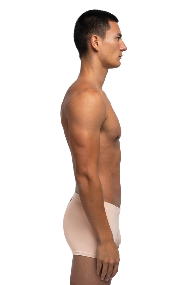 Side view of boxer briefs underwear on model in desert peach colorway. 
